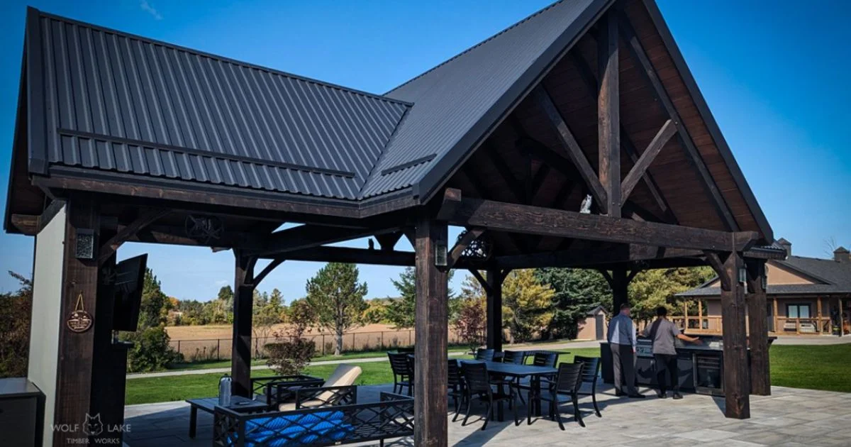 Large timber pavilion with metal roof and outdoor seating